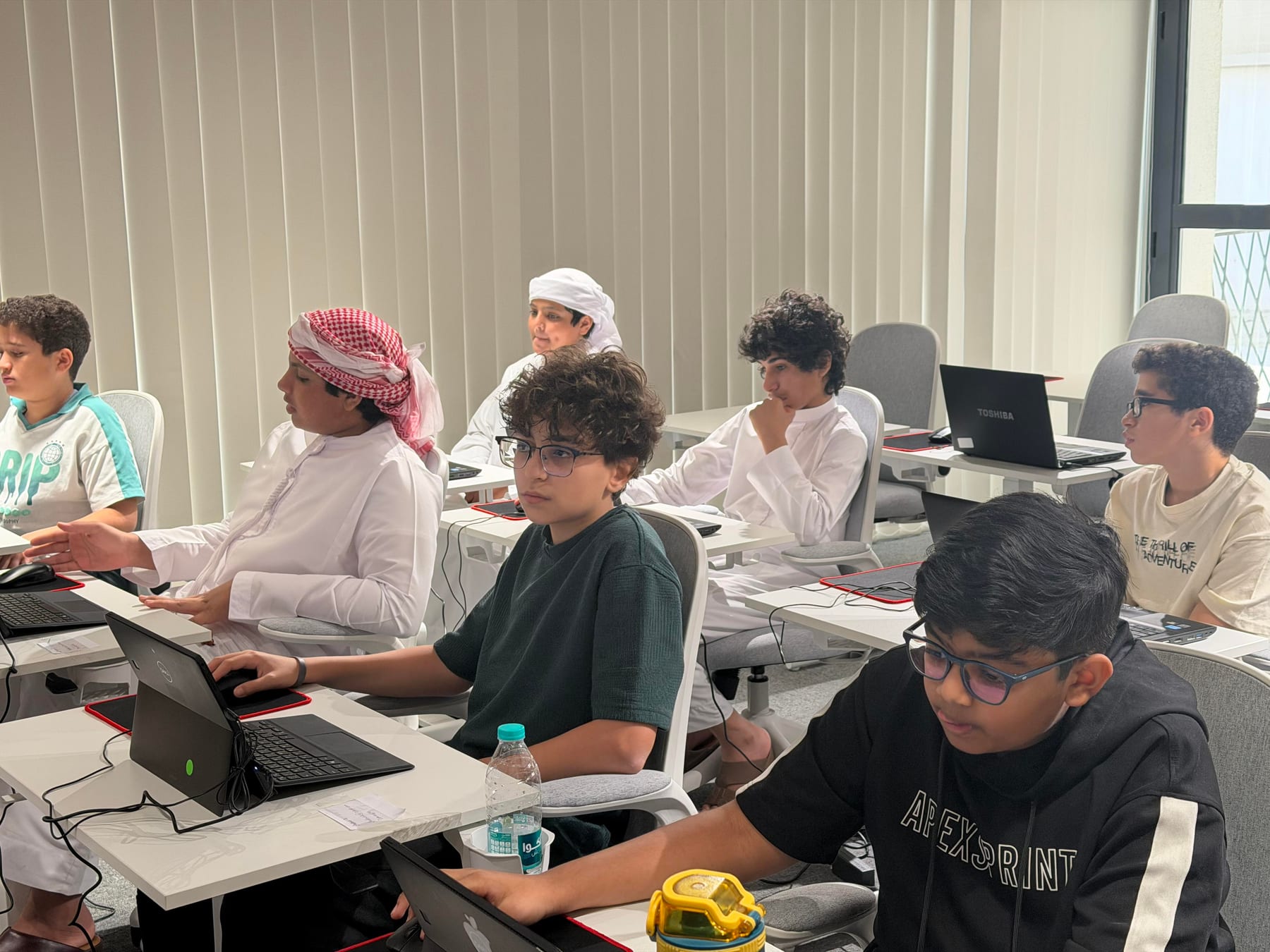 Students, including UAE nationals in traditional dress, in a classroom session